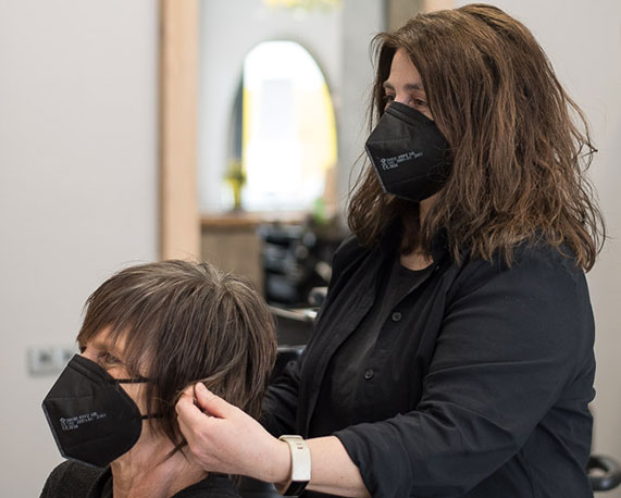 Kundin und Friseurin mit Schutzmaske